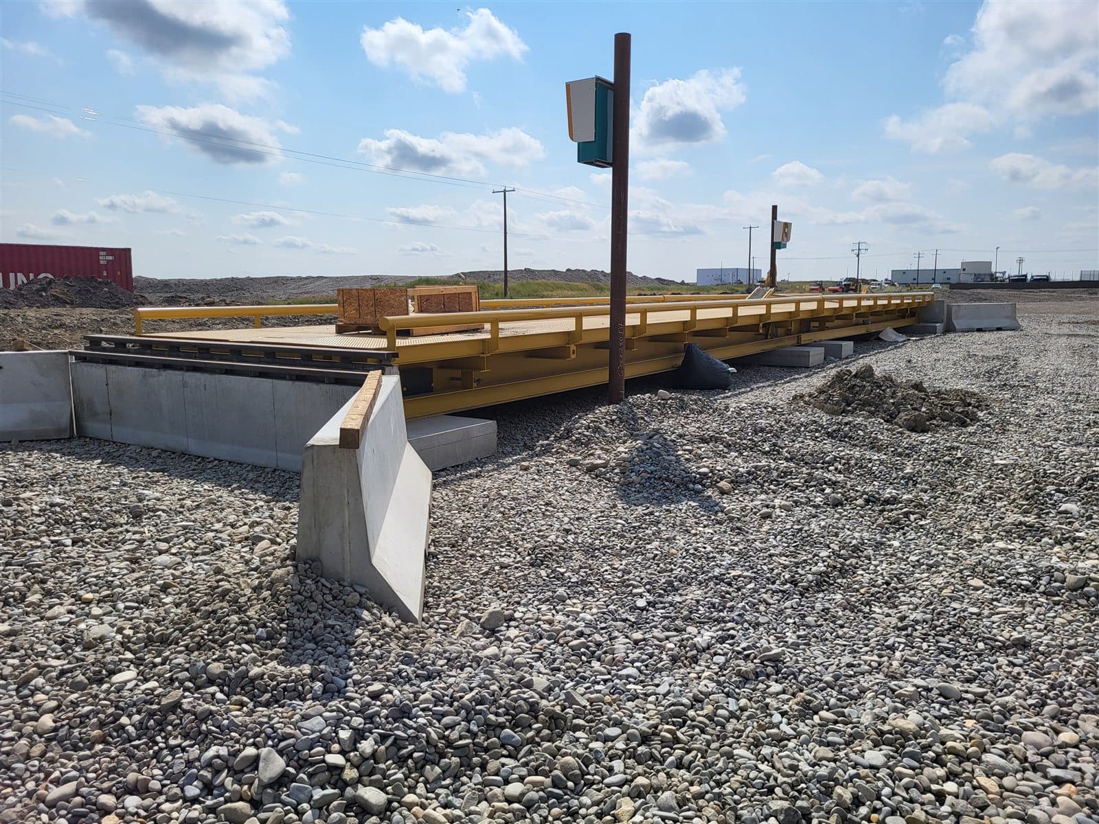 AltaMix precast Jersey barriers lining a truck scale at an industrial site.